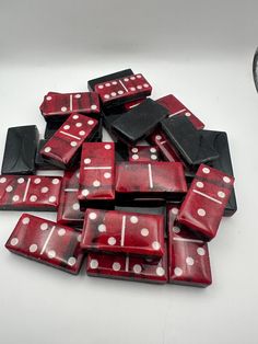 a pile of red and white dices sitting on top of a table next to a clock