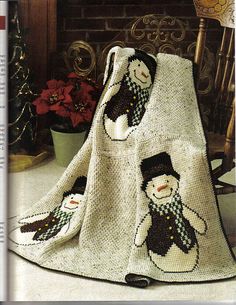 a crocheted blanket with two snowmen on it