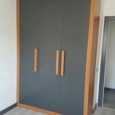 a tall gray cabinet with wooden handles in a room