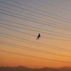 a person on skis flying through the air with power lines and mountains in the background