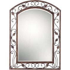 an ornate mirror is shown against a white background and has leaves on the frame, as well as a leafy design