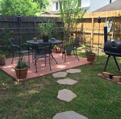 a backyard with a grill, table and chairs