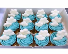 cupcakes with blue frosting and white clouds in a box