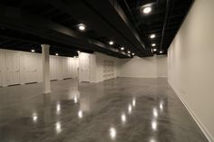 an empty room with white doors and lights on the ceiling is lit by recessed lighting