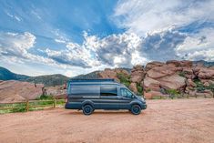 a van is parked in front of some rocks