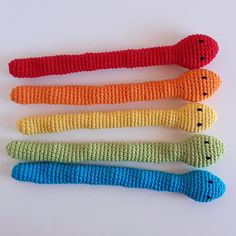 four crocheted objects are lined up on a white surface