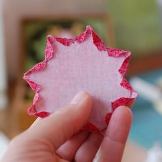 a person holding up a piece of pink paper