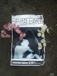 the front cover of crystal castle's magazine with flowers laying on the ground next to it