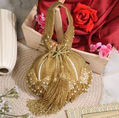 This wedding bridal potli is a beautiful and elegant handcrafted golden potli with fringes and drop pearls on the end. Gold Openable Potli Bag For Wedding, Gold Evening Bag With Pearl Handle For Reception, Gold Handheld Shoulder Bag Gift, Gold Potli Bag With Pearl Handle For Wedding, Elegant Wedding Shoulder Bag With Openable Detail, Elegant Wedding Shoulder Bag With Openable Feature, Wedding Gift Potli Bag, Gold Openable Potli Bag For Party, Gold Handheld Shoulder Bag For Celebration