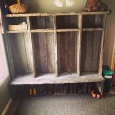 an old wooden shelf with shoes on it in a room next to a stuffed animal