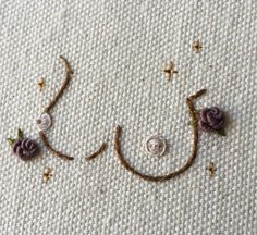 the word joy is made up of flowers and beads on a white surface with gold stars