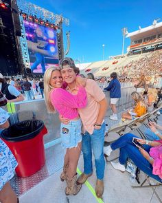 two people hugging each other in front of an audience at a concert or show on the field