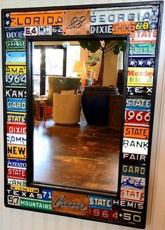 a mirror that is on the wall with many different colors and letters in it,