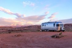 an rv is parked in the desert at sunset