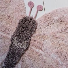 a pair of pink and gray mittens laying on top of a rug