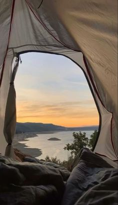 the inside of a tent with water in the background