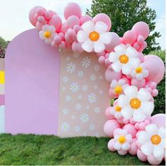 a balloon arch decorated with flowers and balloons