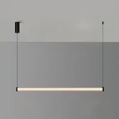 three lights hanging from the ceiling in a room with grey walls and flooring,