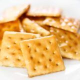 some crackers on a white plate sitting on a table