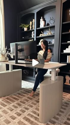 a woman sitting at a desk with a computer