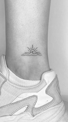 a woman's foot with a small sun tattoo on the left side of her ankle