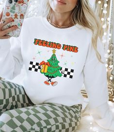 "Embrace the festive spirit with our \"Feeling Pine\" Christmas Sweatshirt, a whimsical and cozy addition to your holiday wardrobe. Crafted from soft, high-quality fabric, this Christmas Tree Sweatshirt combines comfort with a touch of humor. The Funny Xmas Sweatshirt features a charming design that playfully incorporates the pun \"Feeling Pine,\" adding a lighthearted twist to your seasonal style. Whether you're searching for the perfect Christmas Crewneck Sweater, a Christmas Sweater for Women, or a Funny Christmas Sweater to spread holiday cheer, our \"Feeling Pine\" creation is a merry must-have for the season. Bella + Canvas t-shirts and Gilden 18000 heavyweight sweatshirts are featured in my store. They are buttery soft, smooth and so comfy. They are a tried and true favorite of mine Fun Winter Sweatshirt With Letter Print, Fun White Sweatshirt For Winter, Fun Winter Crew Neck T-shirt, Fun Winter T-shirt With Crew Neck, Fun Crew Neck T-shirt For Winter, Funny Graphic Print Sweatshirt For Winter, Fun Winter Crew Neck Sweatshirt, Fun Crew Neck Winter Sweatshirt, Funny Print Winter Sweatshirt