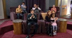 a group of people sitting on top of chairs in front of a red carpeted floor