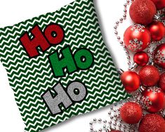 a green and white christmas card with the words ho ho on it next to red ornaments