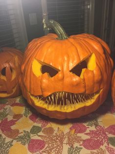 three carved pumpkins sitting on top of a table