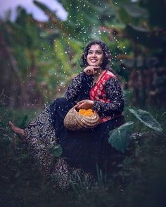 a woman sitting in the rain with an umbrella