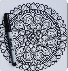 a black and white drawing of a flower on paper with marker pen next to it