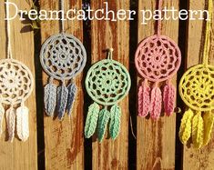 four crocheted dream catchers hanging on a wooden fence with the words creation world written above them