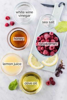 raspberries, lemon juice, and other ingredients are shown in bowls on a marble surface