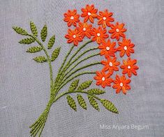 orange flowers are embroidered onto a gray cloth