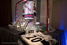 an ice hockey goalie's jersey sits on top of a table next to other memorabilia