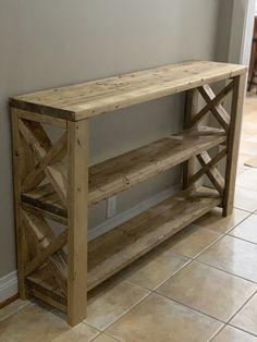 a wooden shelf sitting on top of a tiled floor next to a wall with a door