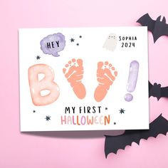 a greeting card with the words hey, my first halloween written on it and an image of a baby's feet