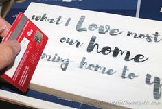 someone is holding a credit card in front of a sign that says, what i love most our home is going home to us