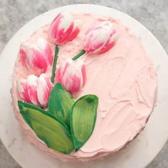 a cake decorated with pink flowers on a white plate