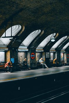 people are sitting on benches at the train station