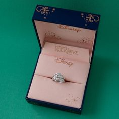 a ring in a box with the disney logo engraved on it's front and side