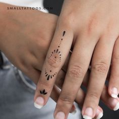 two hands with tattoos on them holding each other