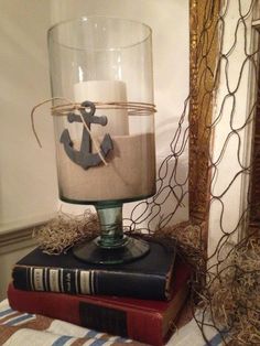 an anchor candle holder on top of two books