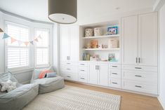 a living room with white furniture and lots of shelves