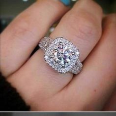 a close up of a person's hand with a diamond ring on their finger