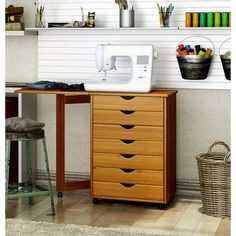 a sewing machine sitting on top of a wooden table next to a shelf filled with craft supplies