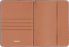 an open tan leather wallet on a white background