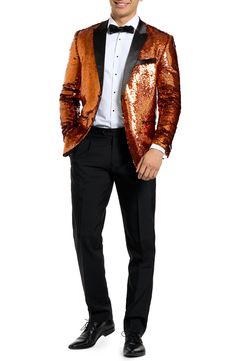 Drenched in golden sequins and finished with satin lapels, the jacket of this entrance-making tuxedo pairs with pleated black trousers and a coordinating bow tie to finish the standout look. Jacket has peaked lapels; four-button cuffs; chest pocket; welt pockets; interior pockets; side vents Trousers have zip fly with button-tab closure; slant pockets; back pockets Jacket is lined Unhemmed 100% polyester Machine wash, line dry Imported Long Sleeve Suits For Night Out And Party Season, Long Sleeve Suits For Night Out Party Season, Long Sleeve Suits For Party Season, Glamorous Fitted Suits For Party, Glamorous Long Sleeve Party Suits, Luxury Long Sleeve Suits For Party, Tailored Gold Suits For Evening, Luxury Long Sleeve Party Suits, Luxury Party Suits