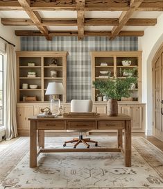 a room with wooden beams and a desk in front of a wallpapered wall