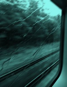 the view from inside a train window looking at trees